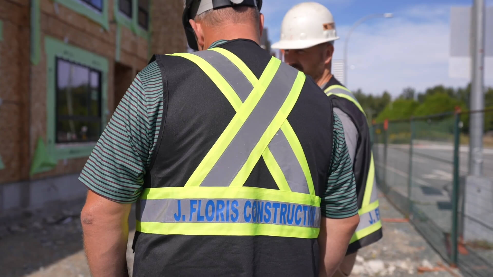 J. Floris Construction worker in a vest facing away from camera